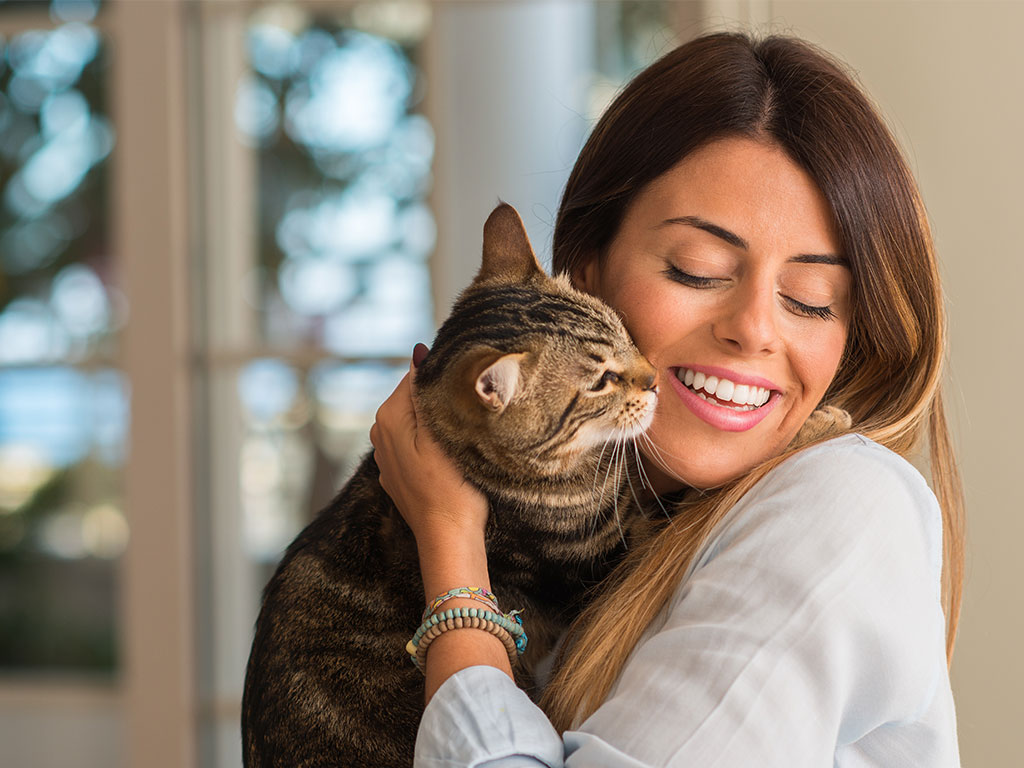 Young Woman Smiling Cuddling Cat